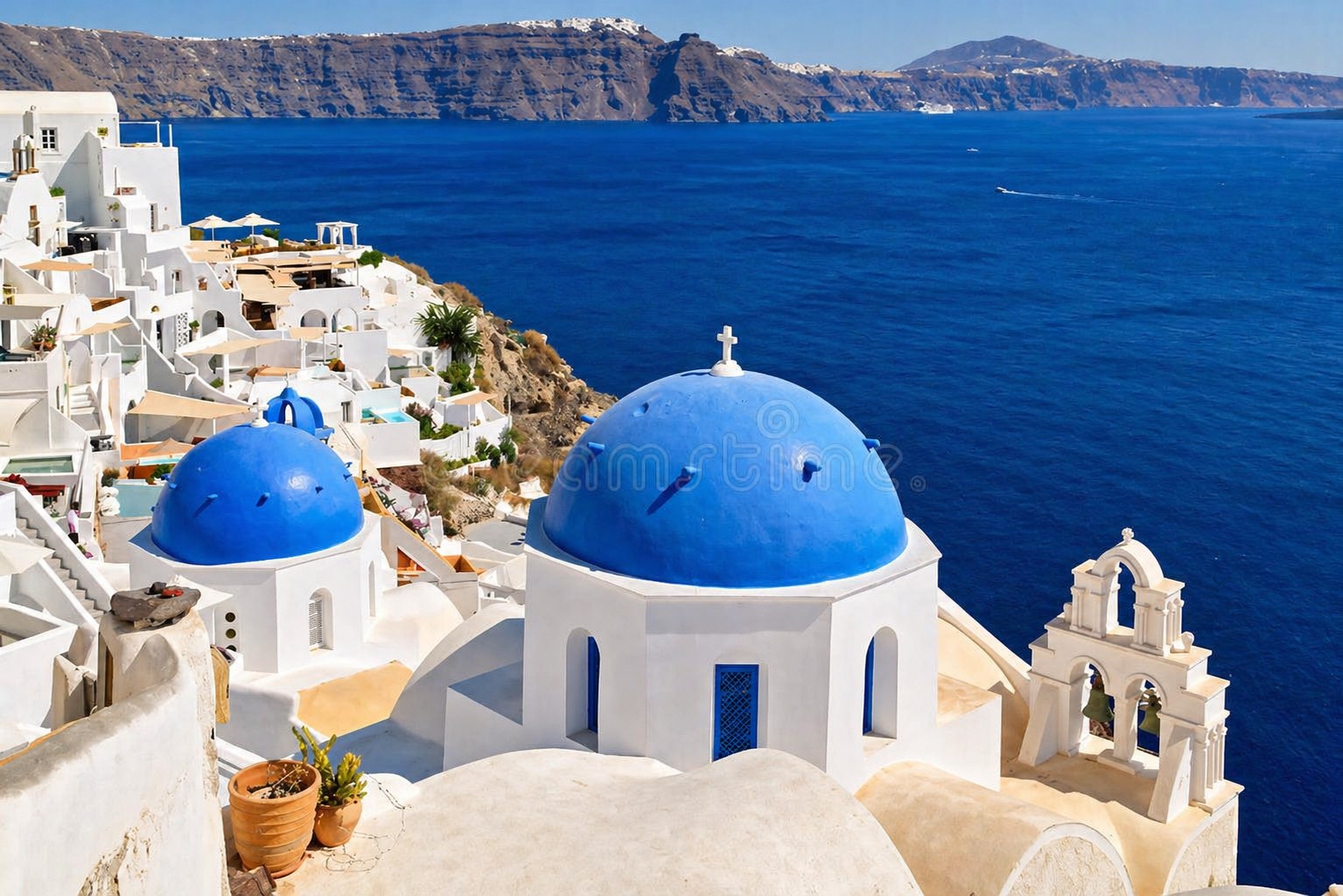 White-domed churches and blue doors of Oia village perched on Santorini caldera cliffs with deep blue Aegean Sea below in bright afternoon light, Greek island photography