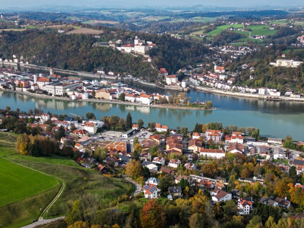 Passau old town at the confluence of three rivers with colorful baroque buildings and St. Stephen's Cathedral dome in soft morning mist, Bavarian river town photography
