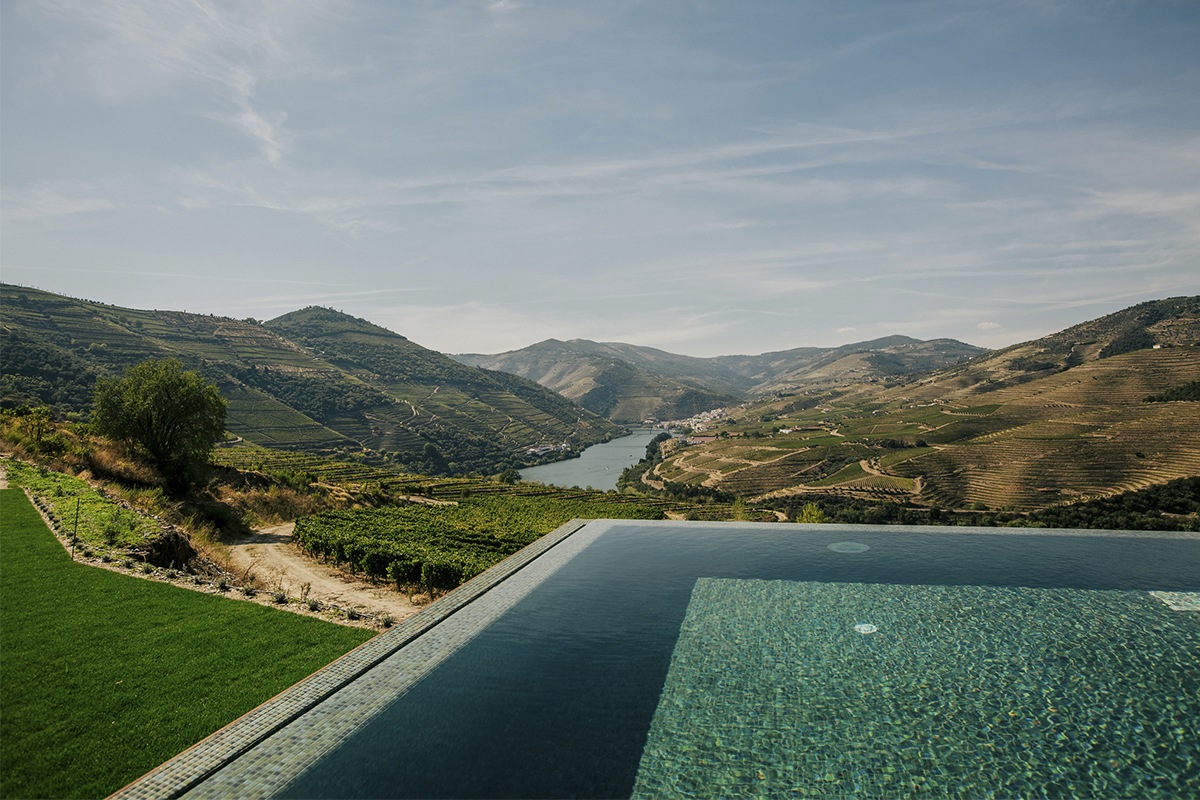 Quinta do Crasto wine estate with terraced vineyards descending to the Douro river and traditional Portuguese manor house in afternoon sunlight, wine estate photography