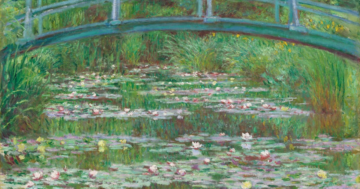 Monet's garden at Giverny with Japanese bridge over water lily pond surrounded by weeping willows and colorful flower beds in bright spring light, Impressionist landscape photography