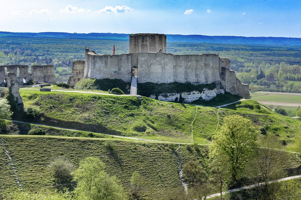 Château Gaillard ruins perched on white chalk cliff above a dramatic bend of the Seine river with green valley below in warm afternoon light, Norman heritage photography