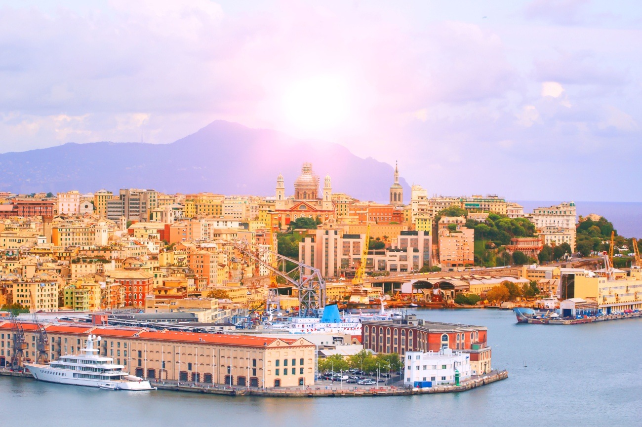 Genoa old port with colorful historic buildings and sailing boats reflected in calm harbor waters during golden hour, Italian Riviera photography