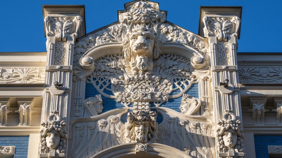 Riga Latvia Art Nouveau building facades with ornamental sculptures and decorative details on quiet tree-lined street in the Quiet Centre district, warm afternoon light, Baltic architectural photography