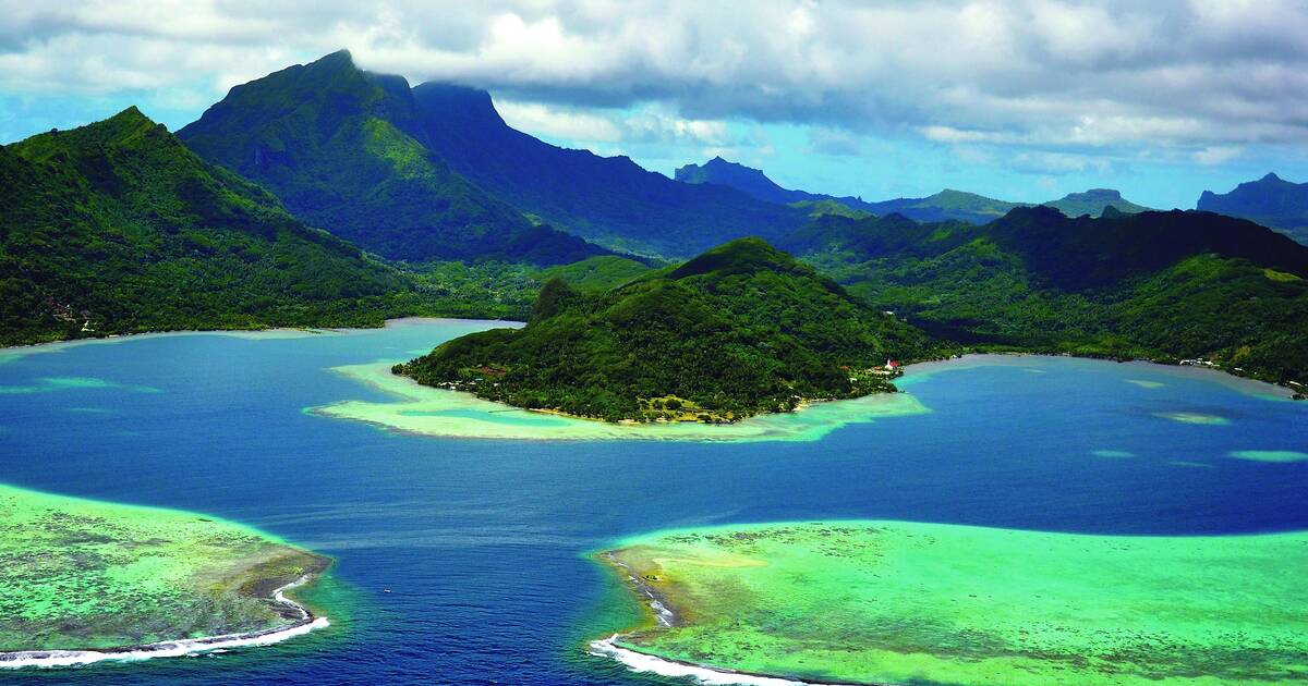 Raiatea island with ancient Taputapuātea marae stone platform sacred site surrounded by tropical vegetation and turquoise lagoon with Taha'a island visible across shared reef, Polynesian heritage photography