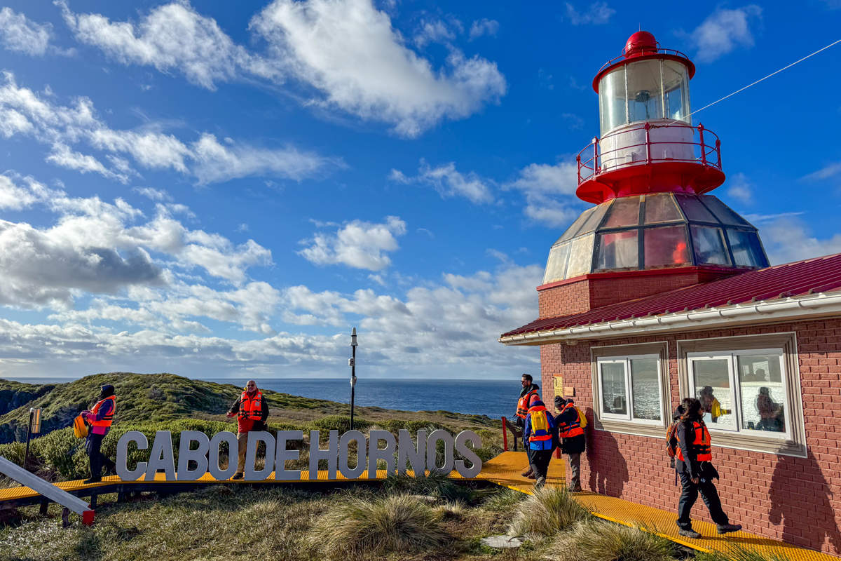 Cape Horn southernmost headland of South America with dramatic cliff face meeting rough Southern Ocean waters and solitary lighthouse visible on windswept promontory, overcast Patagonian sky, end-of-the-world expedition photography