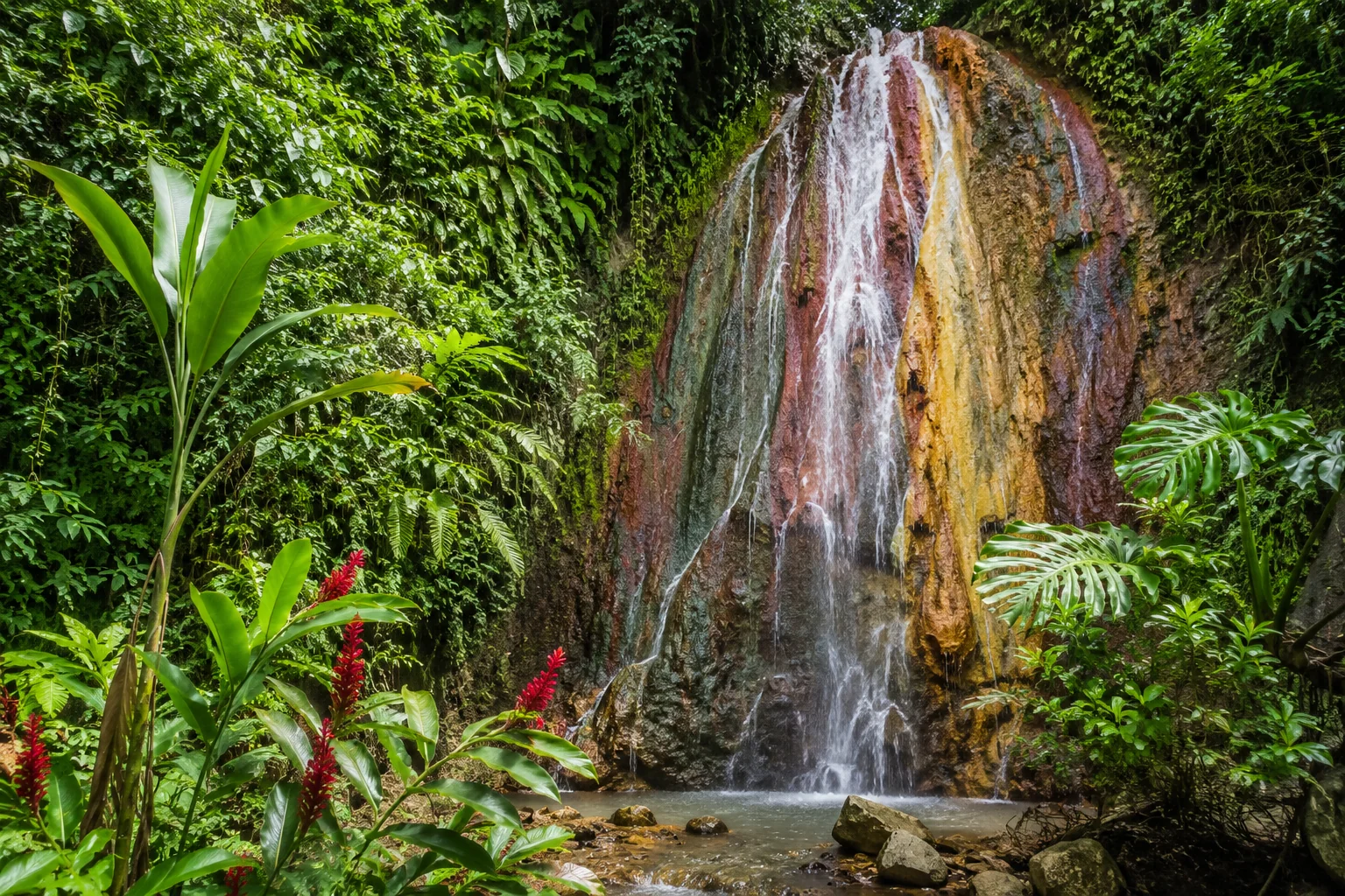 The Pitons twin volcanic peaks rising from turquoise Caribbean Sea with lush green rainforest slopes in Soufrière Saint Lucia, dramatic landscape travel photography