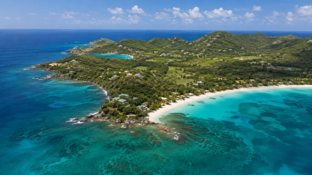 Aerial view of Mustique island with green tropical hillsides white sand beaches and turquoise Grenadine water stretching to t
