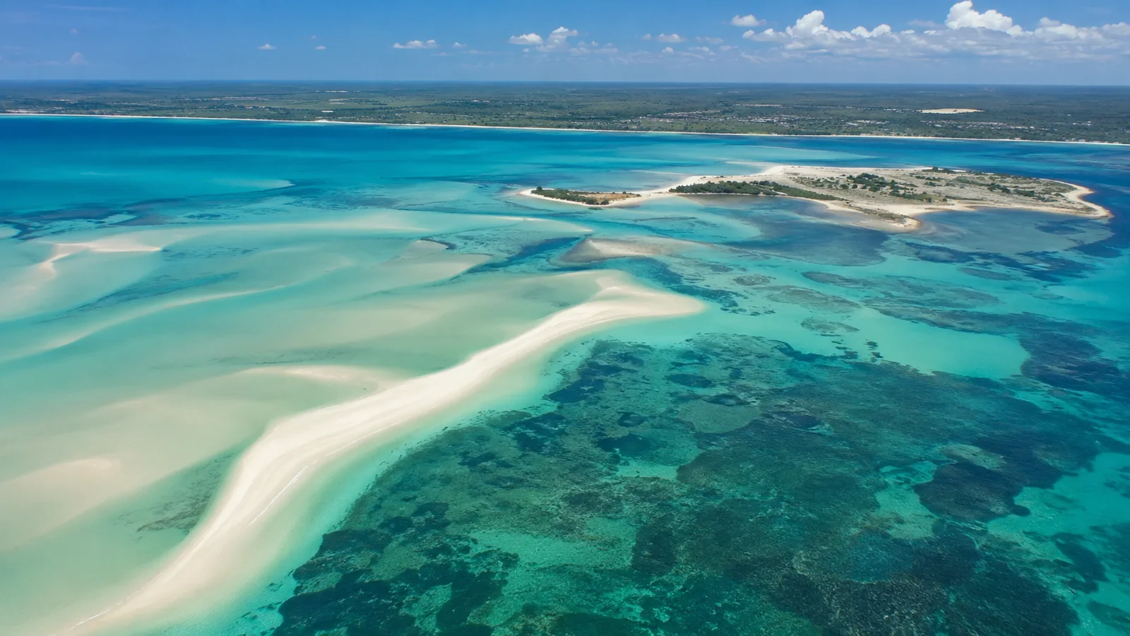 Aerial view of turquoise Indian Ocean water and white sandbanks off the Bazaruto Archipelago Mozambique with the African mainland coastline beyond, tropical travel photography
