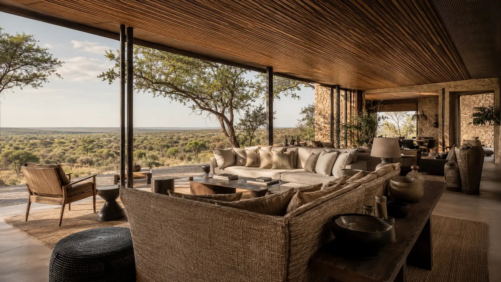 Elegant main lodge area of a Singita property with open-plan design overlooking the African bush, contemporary African interiors with warm wood and neutral tones, luxury safari lodge design photography