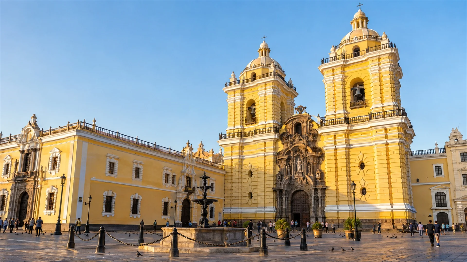 Yellow colonial facade and domed church towers of the Convento de San Francisco in historic Lima under clear sky, warm afternoon light, architectural travel photography