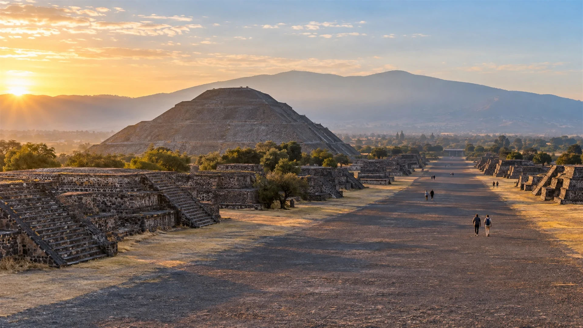 Avenue of the Dead at Teotihuacan with the Pyramid of the Sun in early morning light and mountains behind, few visitors, archaeological travel photography