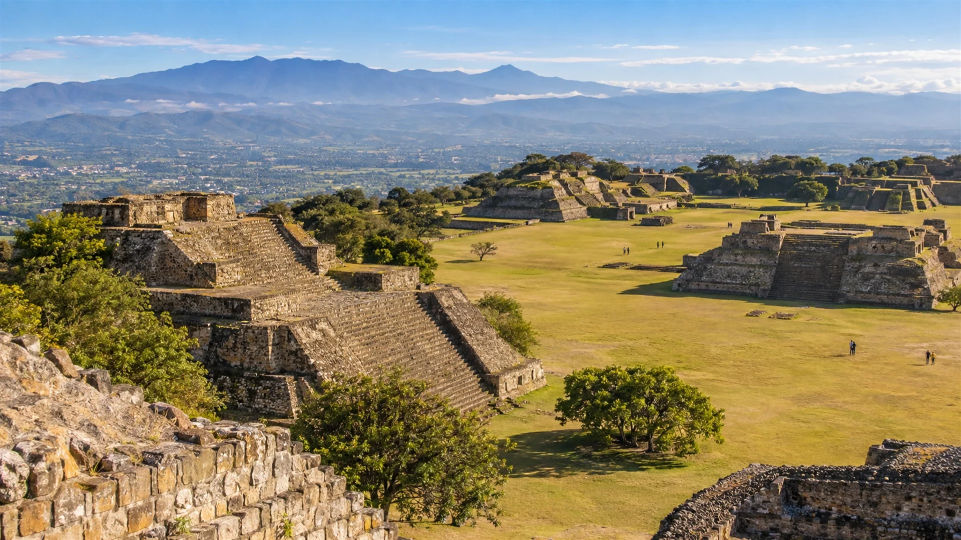 Ancient Zapotec pyramids and grand plaza of Monte Alban on a flattened mountaintop with the green Oaxaca valley below, morning light, archaeological travel photography