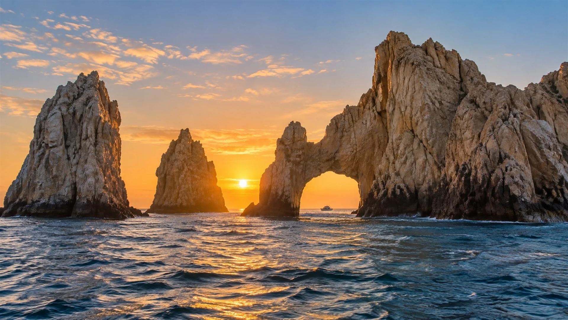 Los Cabos luxury travel scene with El Arco rock formation rising from the Sea of Cortez at sunrise and desert cliffs behind, editorial travel photography
