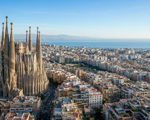 Things to do in Barcelona - modernist spires rising above a dense city grid with the Mediterranean beyond in clear morning li