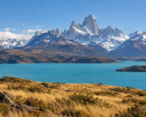 Best time to visit Argentina — granite Patagonian peaks above golden steppe and a turquoise lake under clear summer sky, edit