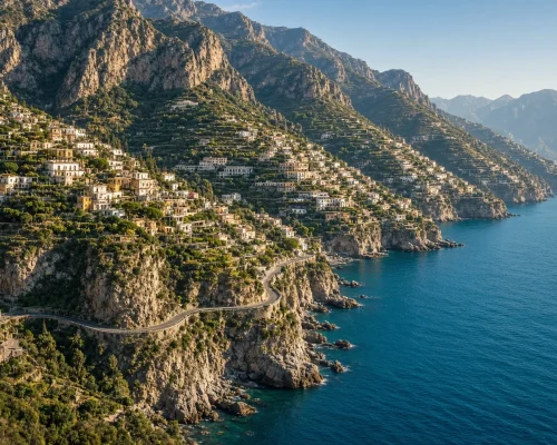 Amalfi coast luxury travel — sweeping view of the cliffside coastline with terraced villages above turquoise sea and winding