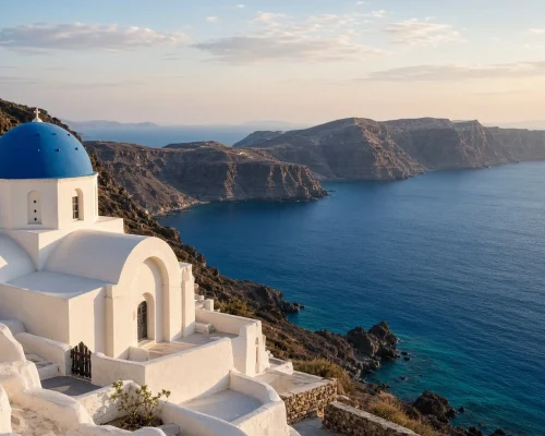 Best time to visit Greece - whitewashed chapel above a deep blue Aegean bay in soft late-summer light with empty terraces and