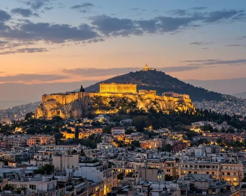 Things to do in Athens - the Acropolis lit above the city rooftops at dusk with Lycabettus hill behind and warm evening haze,